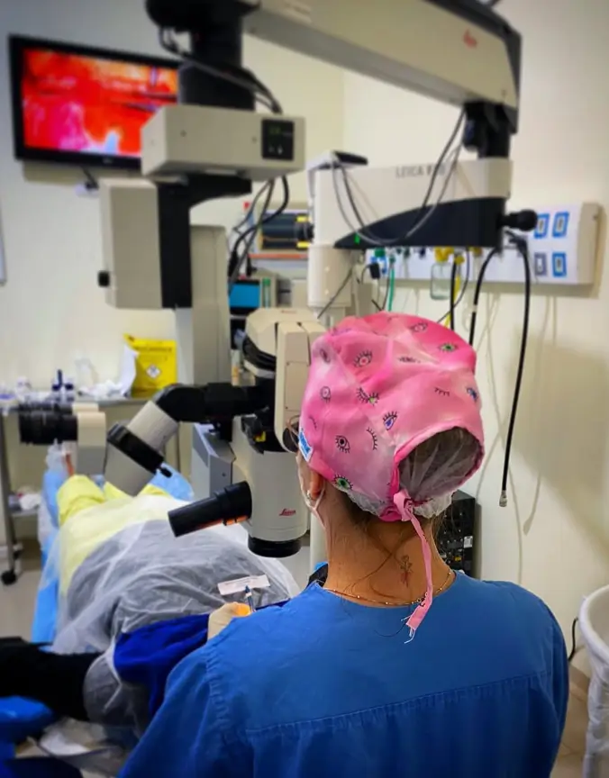 Dra. Thaís realizando cirurgia com microscópio